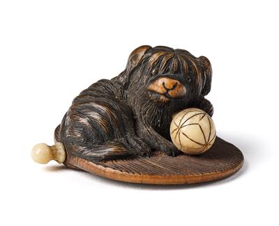 A wood netsuke of a dog with ball on a fan, Japan, c. 1800, indistinctly signed - Asiatics, Works of Art and furniture