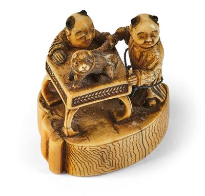 An ivory netsuke of two men with a dog sitting on a table, Japan, Edo period, 19th century, - Mobili