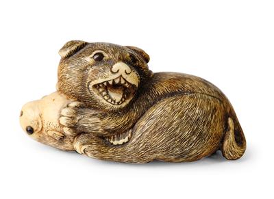 A Netsuke of a Dog with Fish, Japan, Edo Period, 19th Century, - Works of Art - Part 1