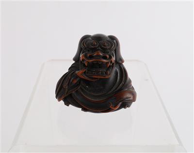 Netsuke eines Sitzenden mit Löwenmaske, - Asiatische Kunst